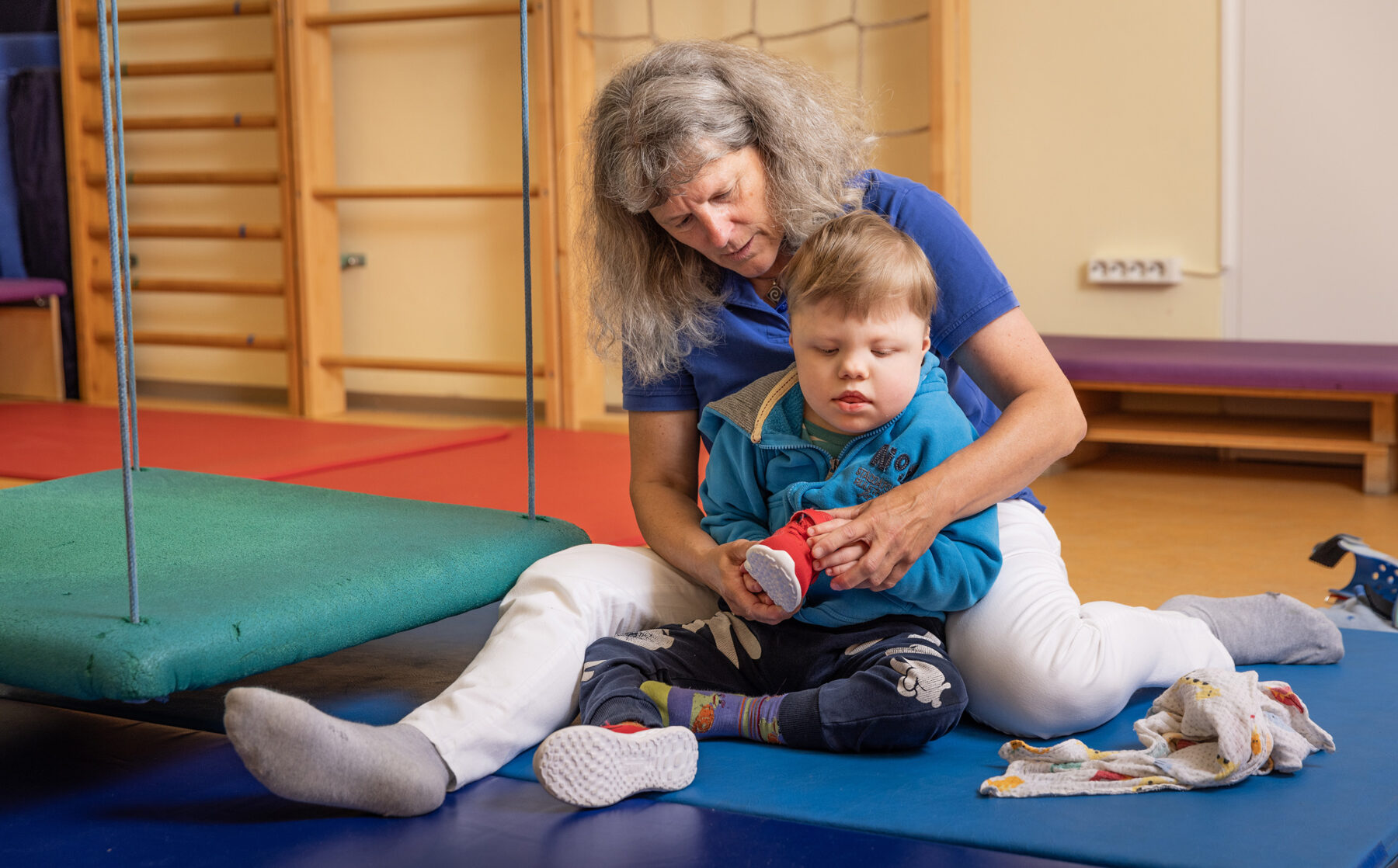Das Üben und Erlernen von Alltagsfertigkeiten wie Schuheanziehen sind auch Bestandteil einer Ergotherapie