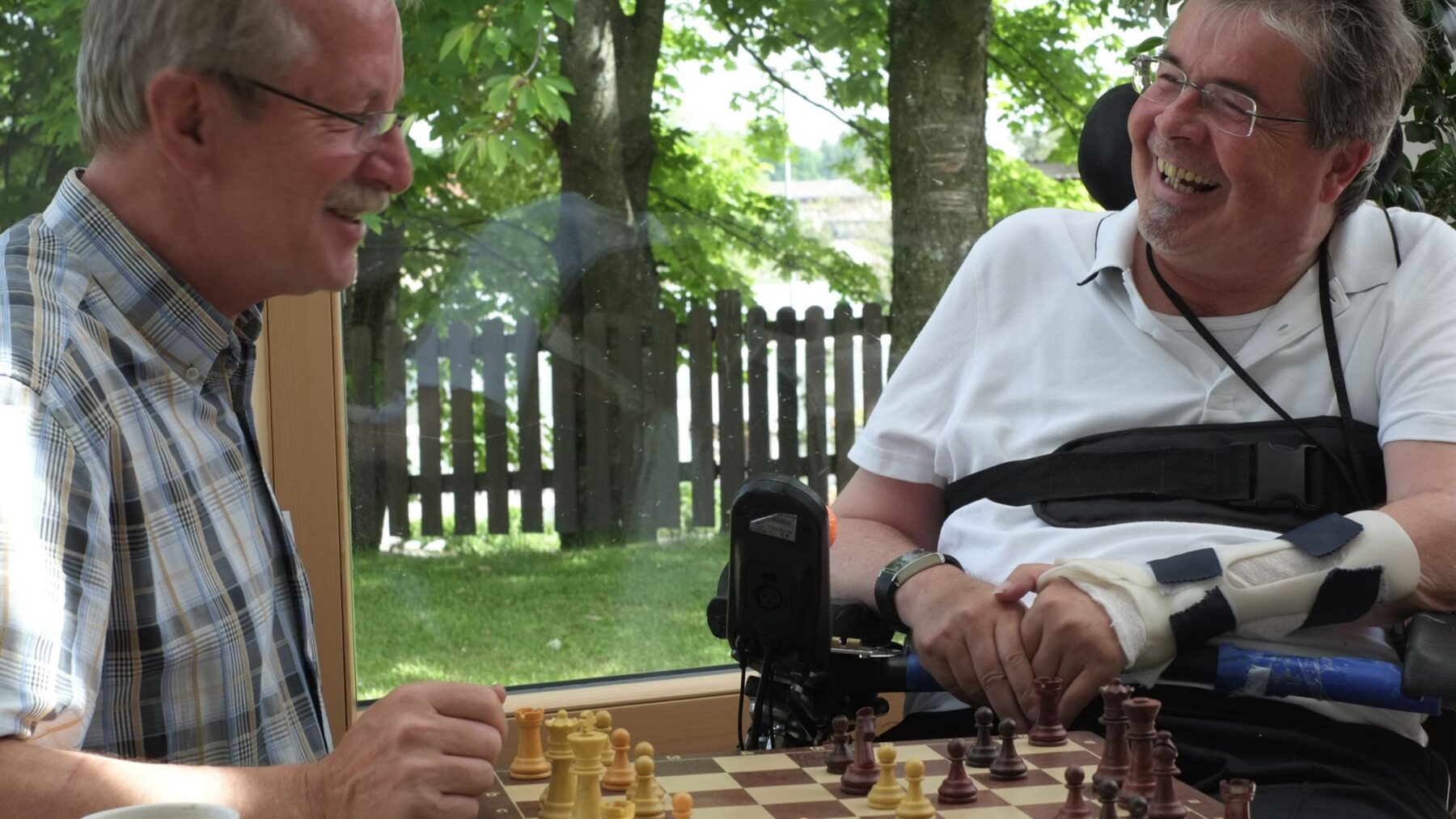Bewohner und ehrenamtlicher Helfer beim Schachspiel