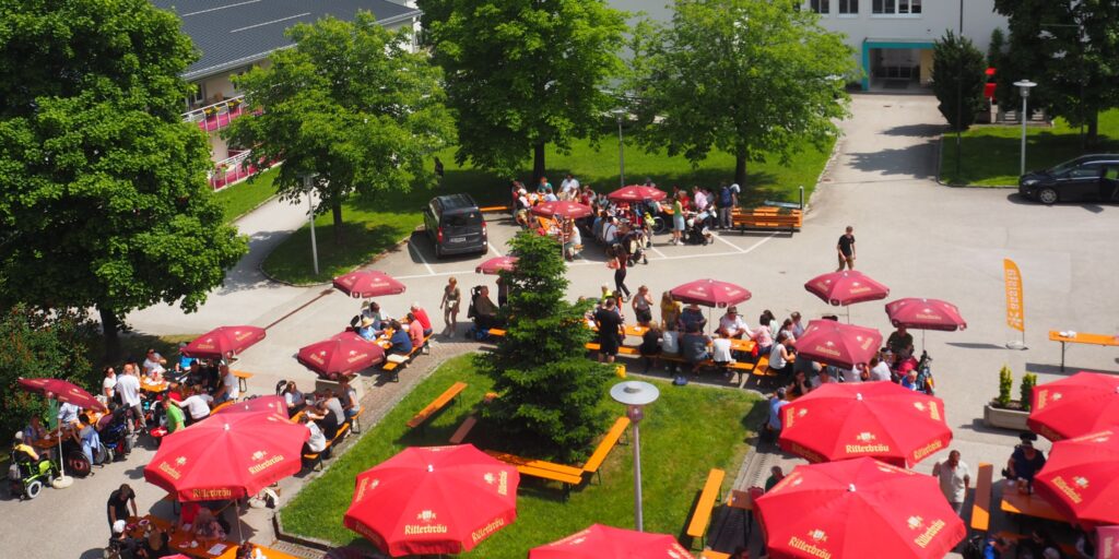 Buntes Treiben unter bunten Sonnenschirmen am Dorfplatz
